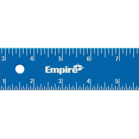 A horizontal close-up detail shot of the blue aluminum layout square centering on the white laser-etched Empire brand name logo, bordered by sharp fractional scale lines along the upper and lower borders.