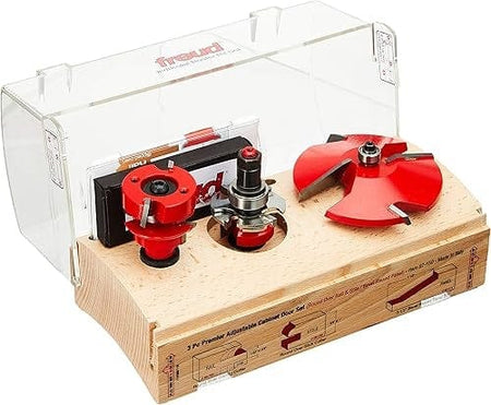 Freud Premier Adjustable Cabinet Door Set displayed on a wooden base with three red router bits under a clear plastic cover. Printed diagrams show each bit’s function for rail, stile, and raised panel cuts.