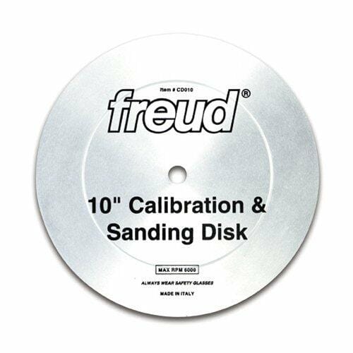 A studio shot of the Freud CD010 10-inch calibration and sanding disc. The silver, toothless metal plate is shown, displaying the Freud logo, its function as a "Calibration & Sanding Disk," and its 6000 max RPM rating.