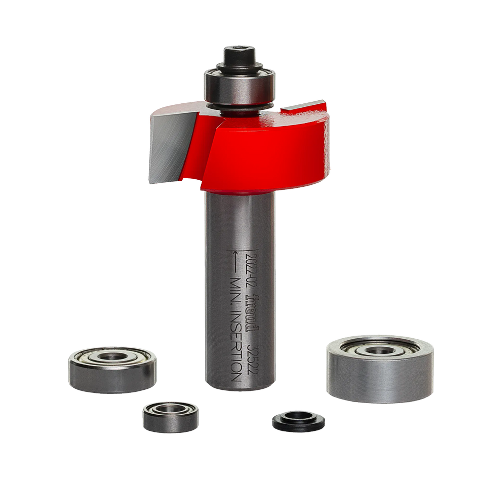 A professional studio photograph of the Freud 32-522 multi-rabbet router bit, showcasing its red Perma-SHIELD coating on the cutting head, silver TiCo carbide edges, and a polished 1/2-inch steel shank, shown alongside its included interchangeable ball bearings of various diameters.