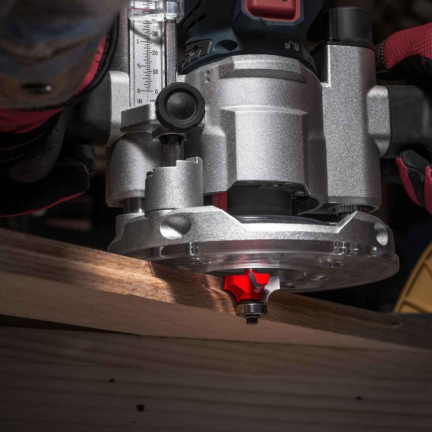 An action-oriented close-up of a Freud rounding over bit mounted in a heavy-duty router, demonstrating the tool creating a smooth, deep 3/4-inch radius rounded edge on a hardwood workpiece.