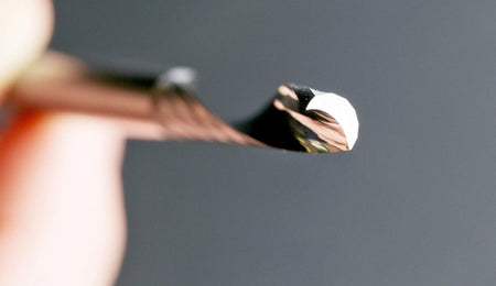 Close-up side view of the sharp cutting edge and spiral geometry of a Freud solid carbide O-flute bit designed for acrylic and ABS.