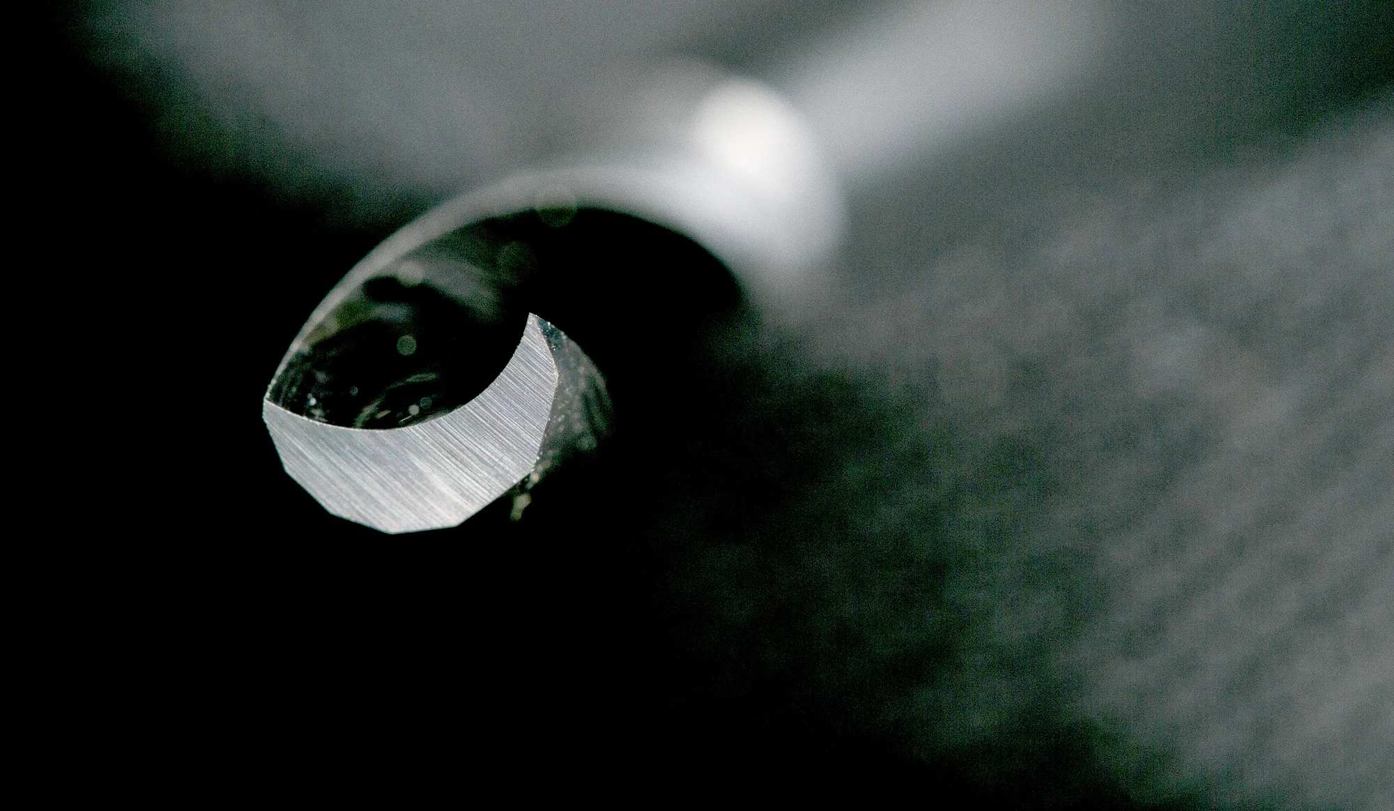Macro view of the top of the router bit highlighting the up-spiral cutting action and high-speed steel finish for clean chip removal in plastics.