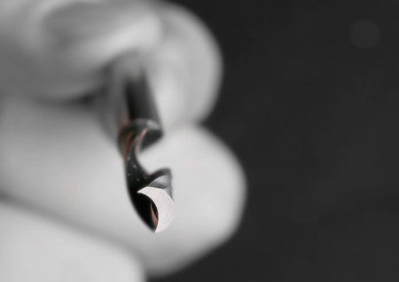 Extreme close-up of the O-flute tip showing the mirror-polished finish and precision ground cutting edge for cool-cutting performance.