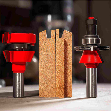 Studio shot of two Freud adjustable rail and stile router bits with red bodies and silver shanks, positioned next to a wooden sample showing the precise shaker profile tongue and groove joinery they create.