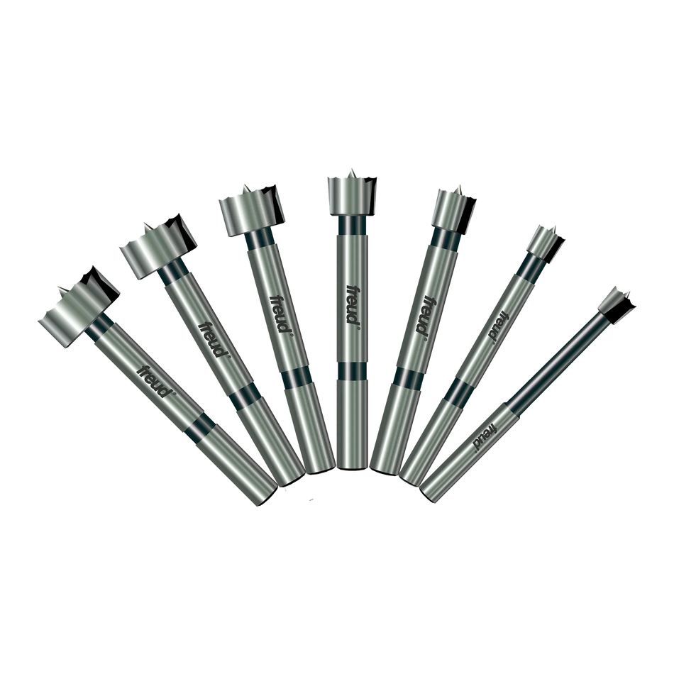 A professional product illustration of the seven carbide Forstner bits included in the Freud PB-107B set, displayed in a fan arrangement to show the progression of sizes from 1/4 inch to 1 inch.