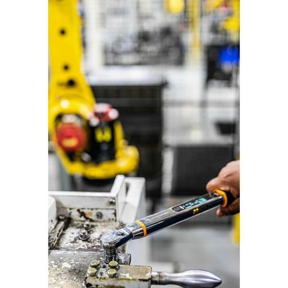 Close-up of a worker using the GEARWRENCH E-Spec electronic torque wrench to secure a series of fasteners on a piece of machinery in an industrial setting.
