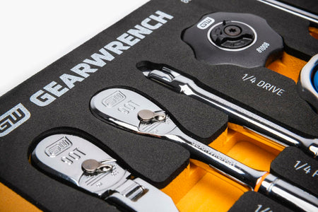 Close-up of GEARWRENCH tools in a foam tray labeled “1/4 DRIVE.” Includes two 90-tooth ratchets, a screwdriver, and a thumbwheel ratchet labeled “81008.” Tools are chrome-finished and organized in labeled compartments