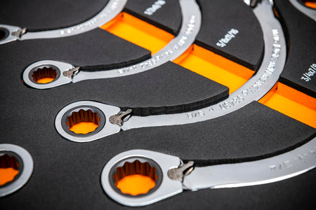 Chrome-finished GEARWRENCH ratcheting box-end wrenches organized in a black foam tray with orange highlights; each wrench labeled with size and features a 12-point ratcheting design.