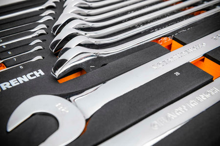 GEARWRENCH 24-piece metric combination wrench set organized in foam tray; chrome wrenches arranged in ascending order from 6mm to 29mm with labeled slots and orange highlights.