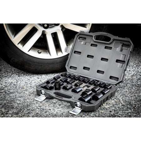 The open GEARWRENCH blow mold case, filled with the 25-piece impact socket set, rests on asphalt next to a car wheel.