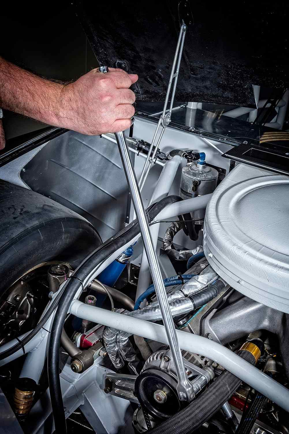 An action photo of a technician's hand using a long GEARWRENCH 1/2 inch drive breaker bar to apply high-leverage torque within a complex vehicle engine compartment.