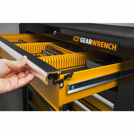 A close-up view of a hand opening one of the mobile work station's top drawers, showing the aluminum drawer pull and the yellow customizable tool partitioning system inside.