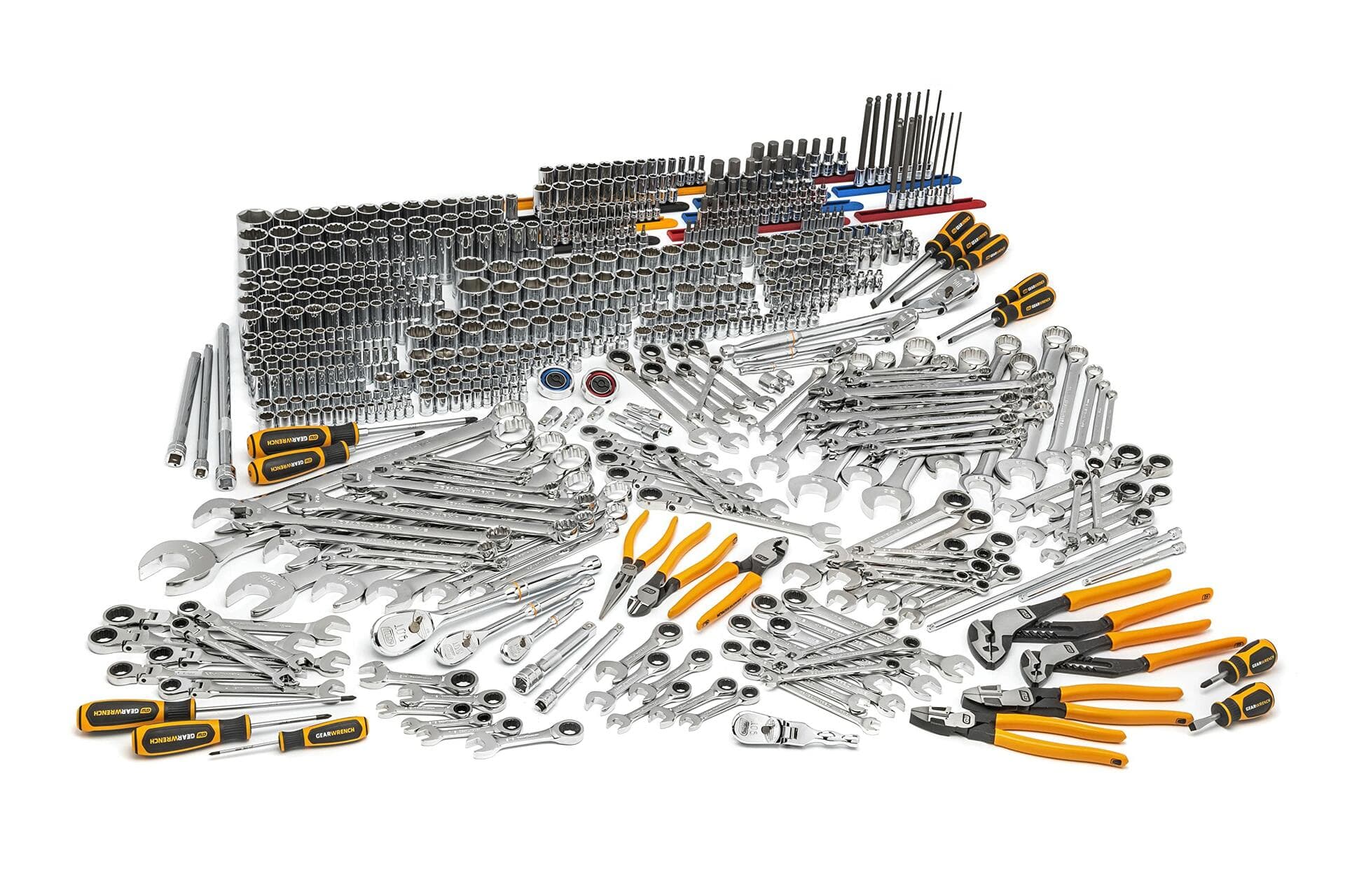 Wide-angle view of a comprehensive mechanics tool set laid out on a white background. Includes socket wrenches, ratchets, combination wrenches, screwdrivers, pliers, torque wrenches, hex keys, and specialty tools. Designed for professional-grade automotive and industrial use.