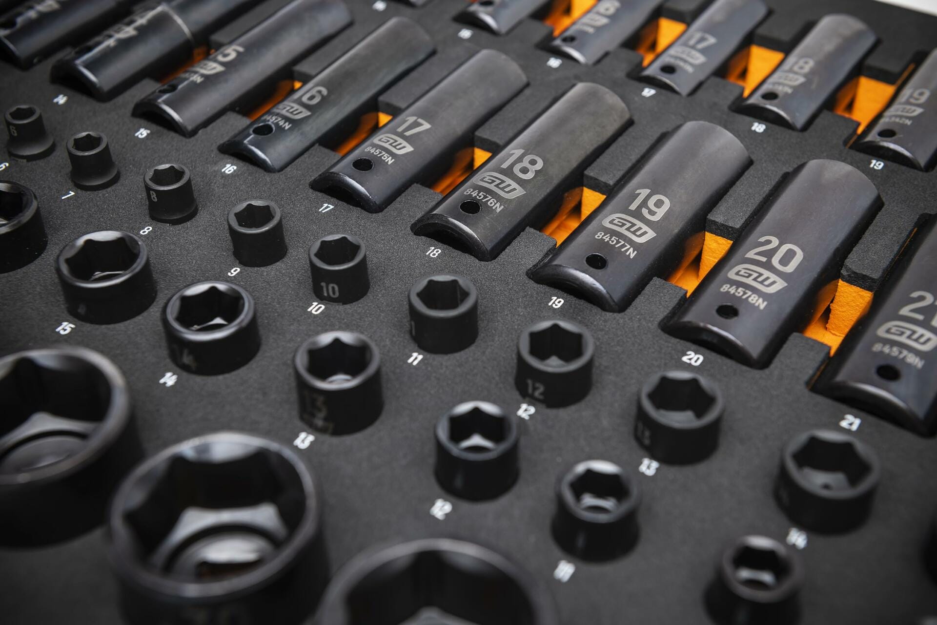 Foam tray containing deep and shallow metric impact sockets labeled from 10mm to 22mm; sockets marked with brand and part numbers for easy identification and organized access