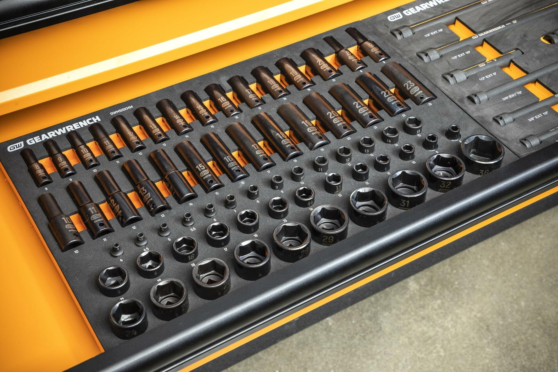 "GEARWRENCH impact sockets and wrenches organized in a foam drawer insert; sockets labeled with metric sizes and arranged in rows by depth and diameter for professional tool chest integration.