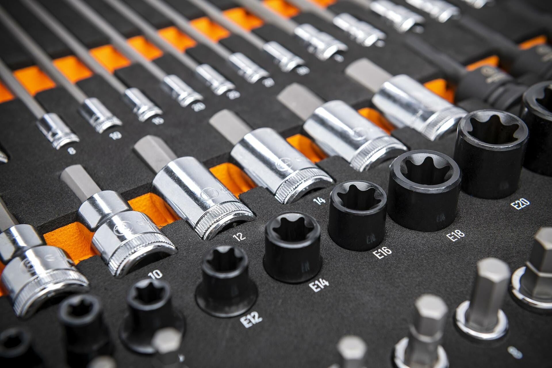Organized tray of metric hex and external Torx sockets with labeled sizes; chrome and black oxide finishes arranged in rows for mechanical and automotive applications.
