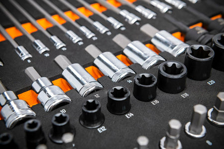 Organized tray of metric hex and external Torx sockets with labeled sizes; chrome and black oxide finishes arranged in rows for mechanical and automotive applications.