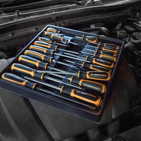 A lifestyle shot of the GEARWRENCH 80066H 20-piece set resting in its storage tray on top of a vehicle's engine, highlighting organized tool management in a professional automotive environment.