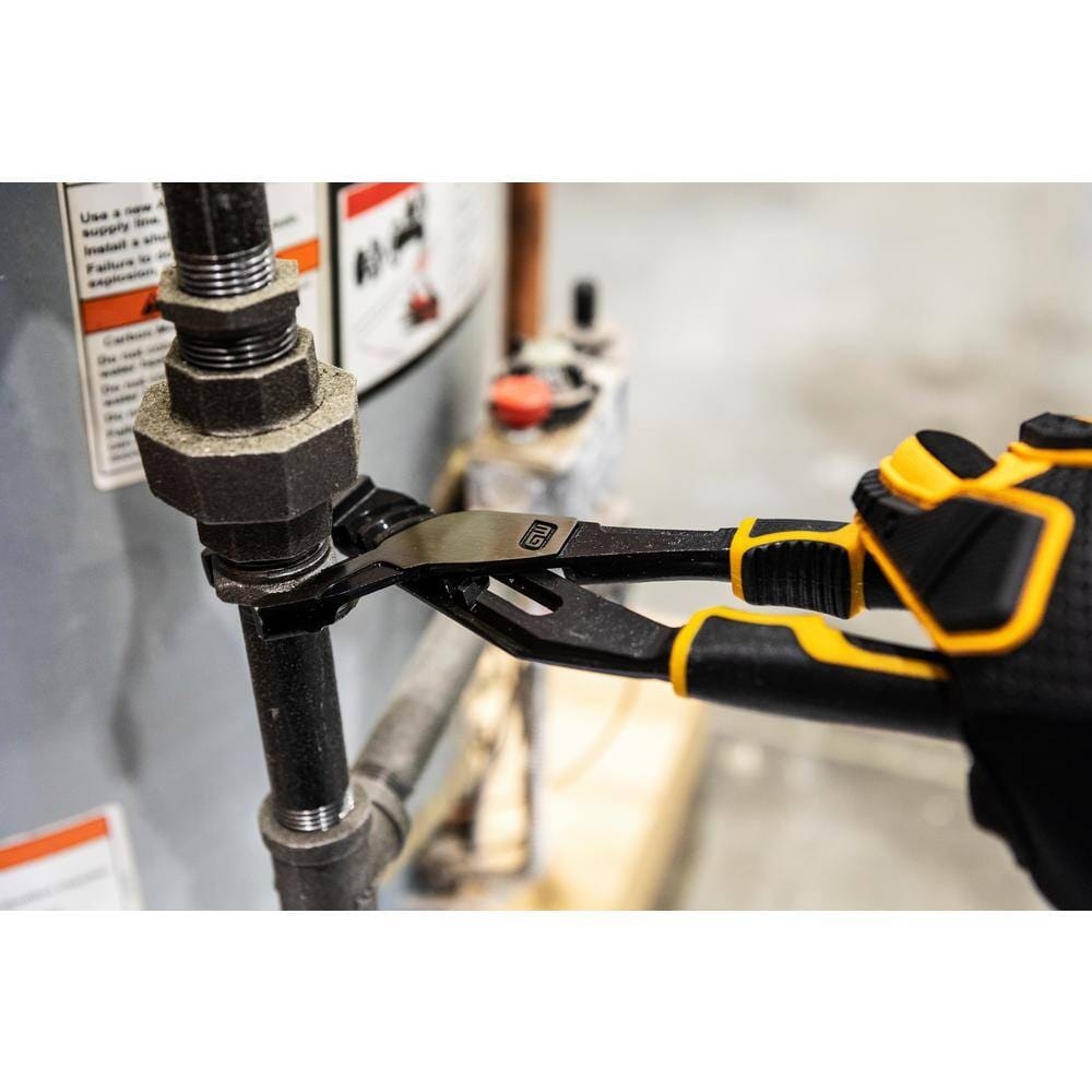 Close-up action shot of the GEARWRENCH 8-inch PITBULL pliers tightening a plumbing hex nut on a black iron pipe, showcasing the aggressive biting power of the V-Jaw design.