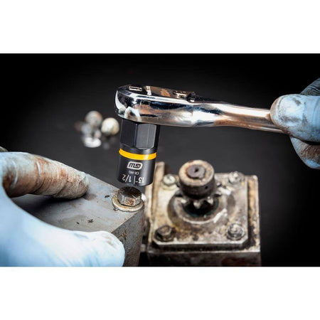 Close-up of a mechanic using a GEARWRENCH Bolt Biter impact extraction socket with a standard hand ratchet to securely grip and remove a rusted and stripped bolt from a heavy-duty industrial surface.