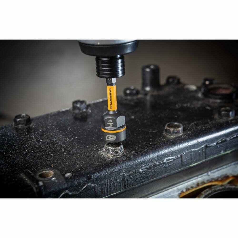 A GEARWRENCH Bolt Biter nut extractor in a drill is positioned over a bolt on a dirty black engine valve cover.