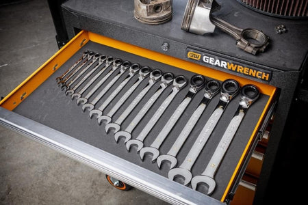 A lifestyle shot of the GEARWRENCH 86629 metric wrench set organized in a professional tool chest drawer alongside engine components, showcasing the long beam design and organized storage.