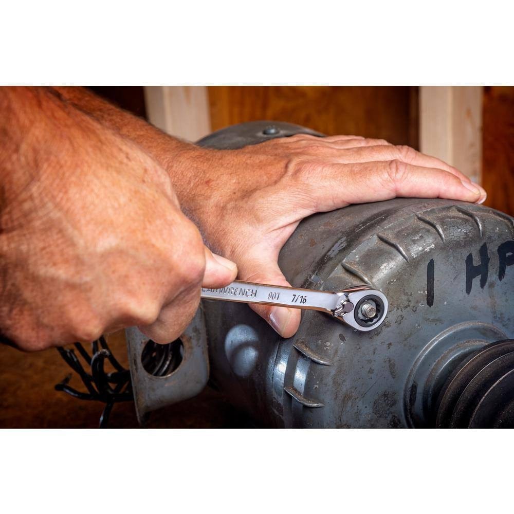 A professional using the GEARWRENCH 7/16 inch ratcheting wrench to tighten a bolt on an industrial electric motor, showcasing the 12-point box end's secure grip and the tool's long beam leverage.