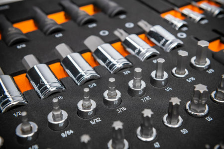 Chrome-finished SAE socket bits arranged in rows on a labeled tray; includes hex, Torx, and standard sockets ranging from 5/32 to 9/16 inches for mechanical and automotive applications.