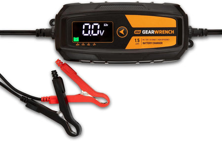 A studio product view of the GEARWRENCH 1.5A battery charger and maintainer. The image shows the main digital control unit with a black and molten orange housing, accompanied by the heavy-duty red and black battery terminal clamps.