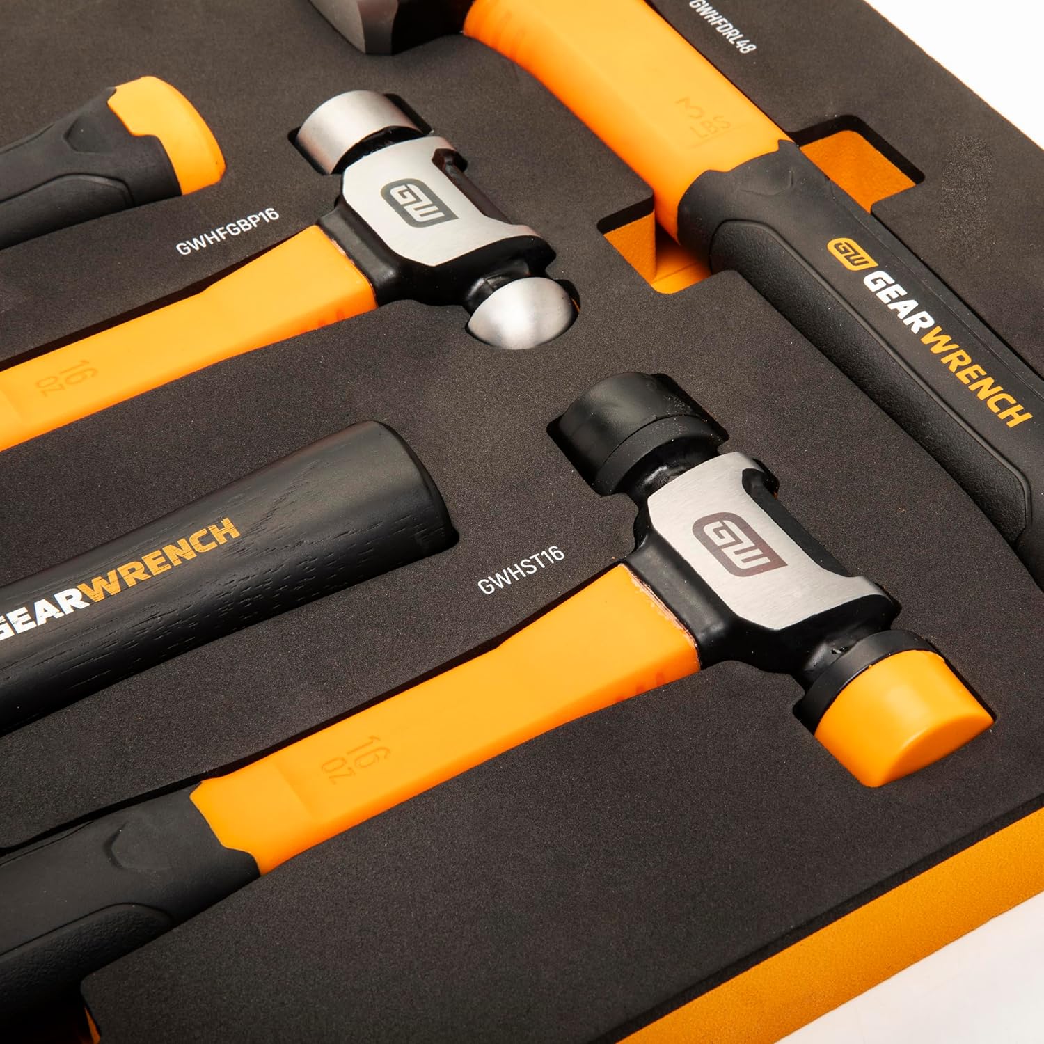 A macro close-up view focusing on the dual-function ball pein, soft tip, and high-force drilling hammer heads nested in the protective closed-cell black foam tray inserts to illustrate technical model labeling.