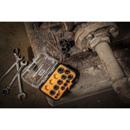 DEWALT socket bit set in yellow case with combination wrenches on rusted metal surface near pipe structure.