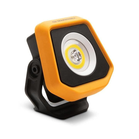 Rugged GearWrench LED shop light with yellow-orange border and central bulb, mounted on a black adjustable stand for angled illumination in garage or jobsite settings.
