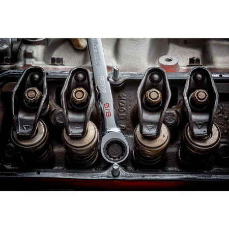 Top-down view of a GearWrench 120XP 5/8 inch ratcheting wrench tightening a valve cover bolt on an engine block.