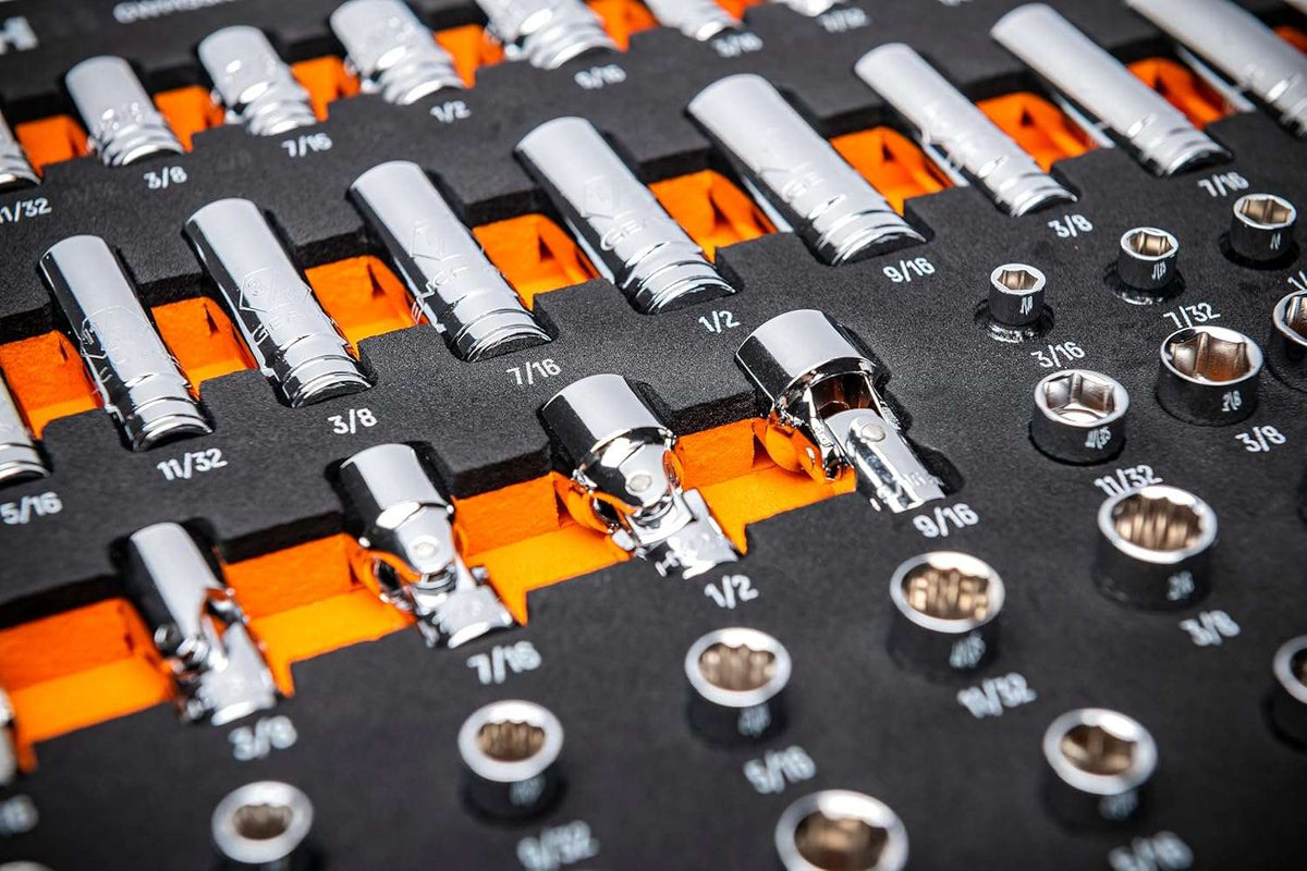 Close-up angled view of deep and standard chrome sockets organized in a high-contrast foam tray with visible size markings.