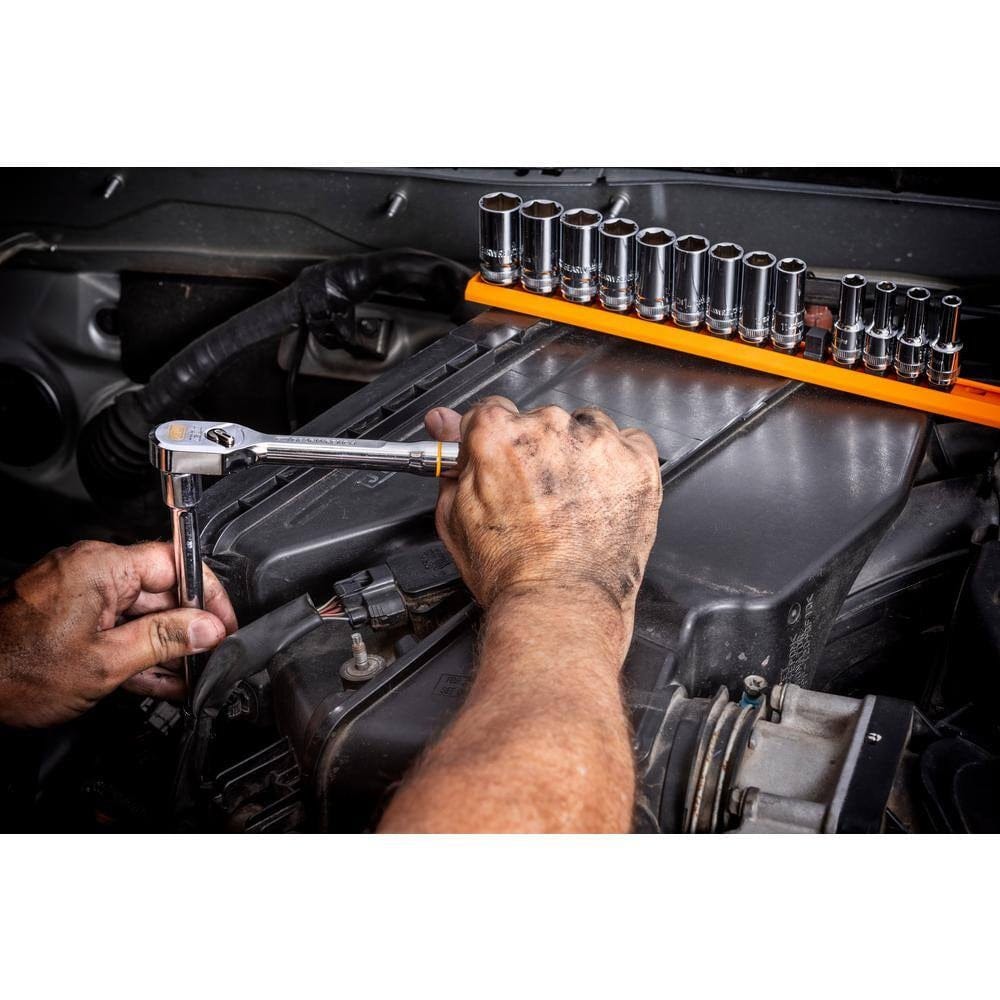 Close-up of a person using a ratchet wrench on a car engine with visible socket organizer and intake components.