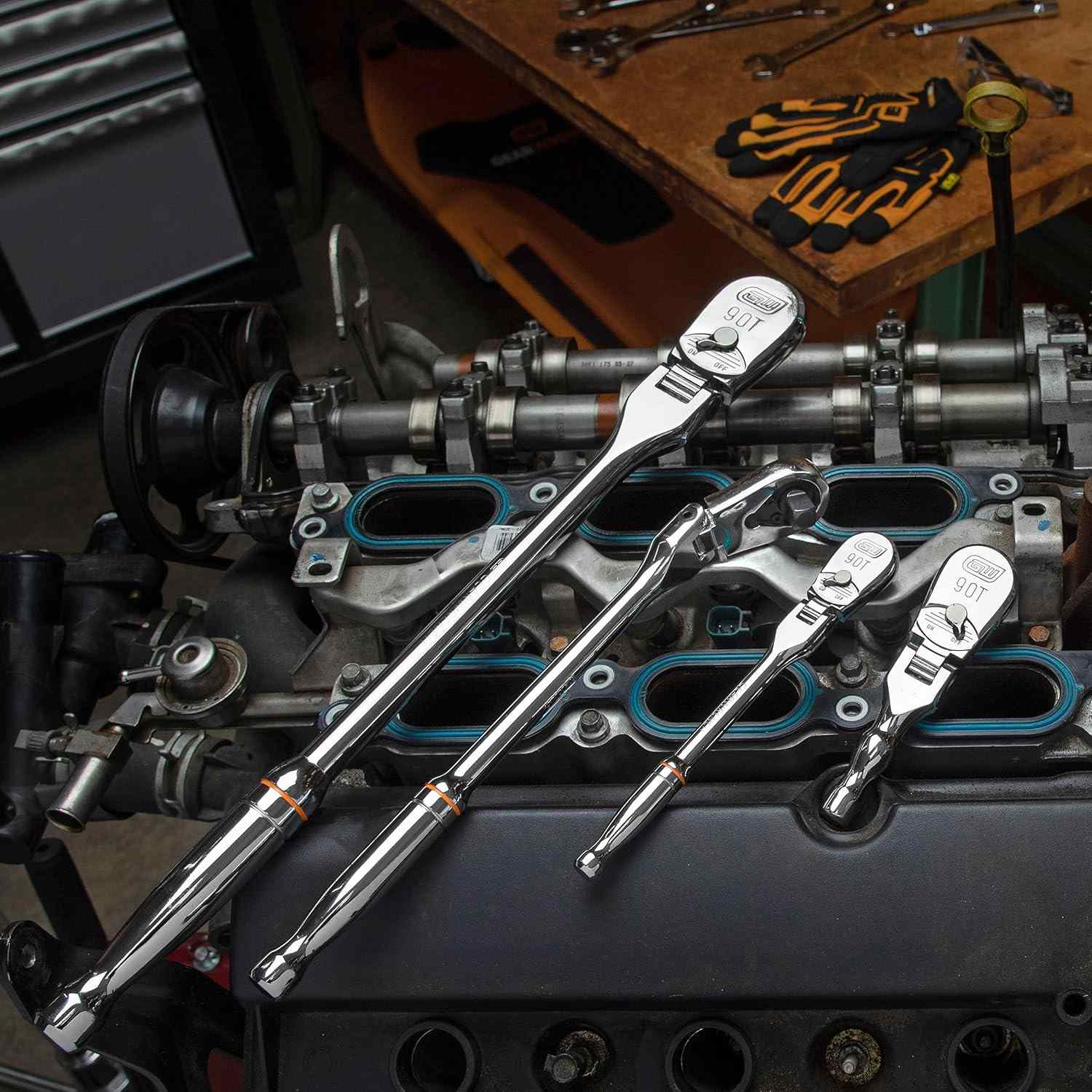 All four GEARWRENCH 90-tooth flex-head ratchets from the set are displayed on top of a disassembled car engine.