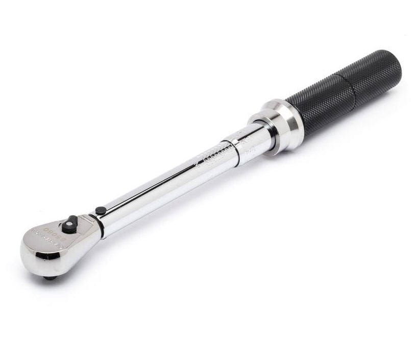 Torque wrench with ratcheting head and knurled grip, designed for precise torque application in mechanical work.