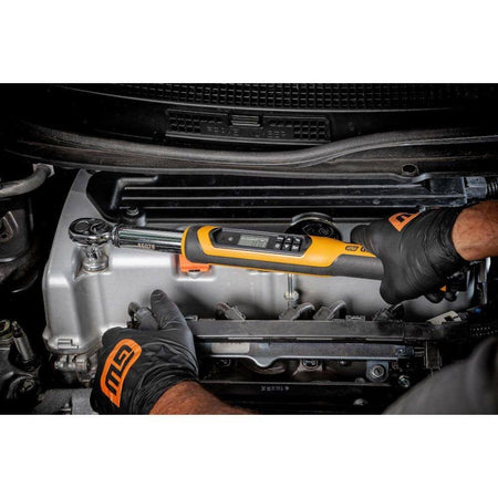 Person using a GearWrench digital torque wrench on a car engine, wearing black gloves with orange accents.