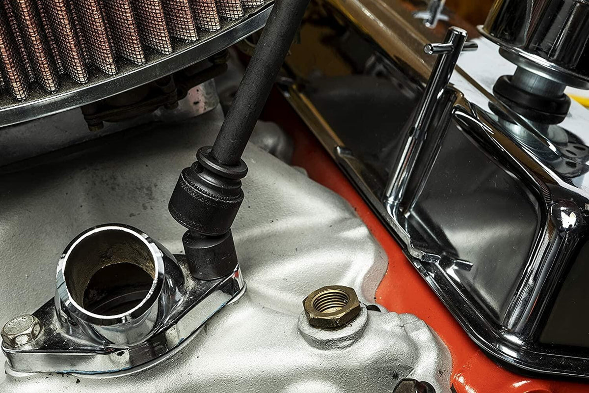 A close-up view of a universal impact socket from the GearWrench 89092 set engaged with a bolt in a tight engine bay, demonstrating its access in confined spaces near an air filter and chrome components.