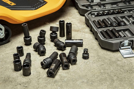 An assortment of GearWrench 89092 3/8-inch drive metric impact sockets, including standard, deep, and universal types, scattered on a concrete floor next to the open storage case and a yellow mechanic's creeper.