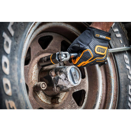 Technician utilizing a heavy-duty breaker bar and GearWrench deep socket to break loose a seized wheel lug nut.