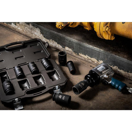GearWrench 3/4-inch drive impact sockets and storage case arranged on a workshop floor next to a pneumatic impact wrench and industrial piping.