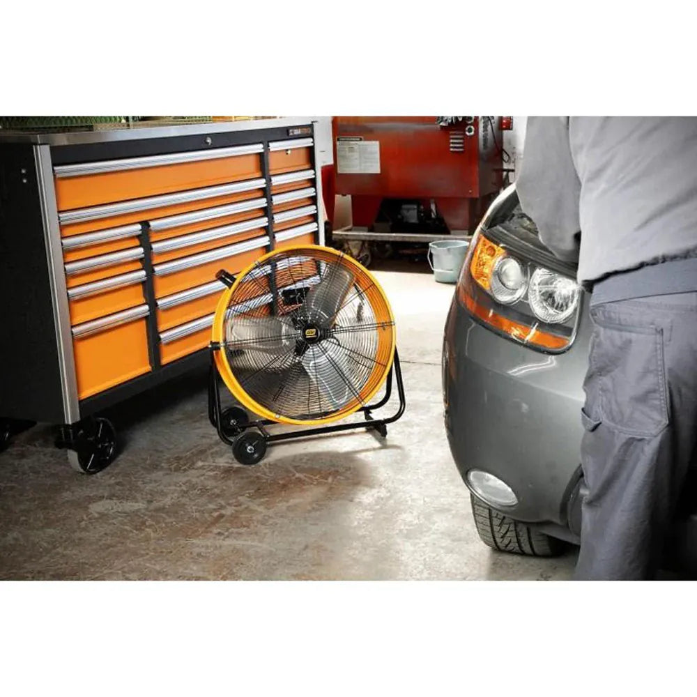 GearWrench 24-inch shop fan operating in an automotive garage next to a tool chest to ventilate a vehicle service bay.