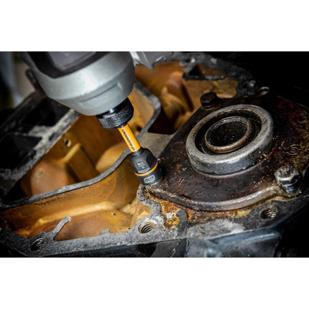 Using a cordless impact driver with the GEARWRENCH Bolt Biter to extract a rusted timing cover bolt on an engine block.