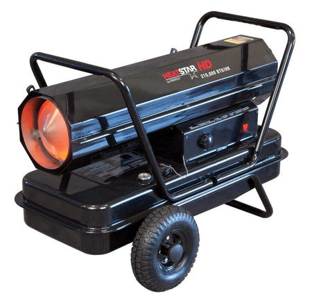 Studio angle view of the black Heatstar HD HS210KT forced air heater featuring a cylindrical barrel with an orange glowing interior, mounted on a large fuel tank with pneumatic tires and a tubular steel handle frame, showing the side control panel with thermostat knob