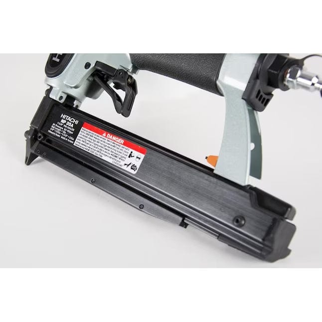 A close-up studio shot of the magazine and trigger area of the Hitachi NP35A pin nailer, showing the warning label.