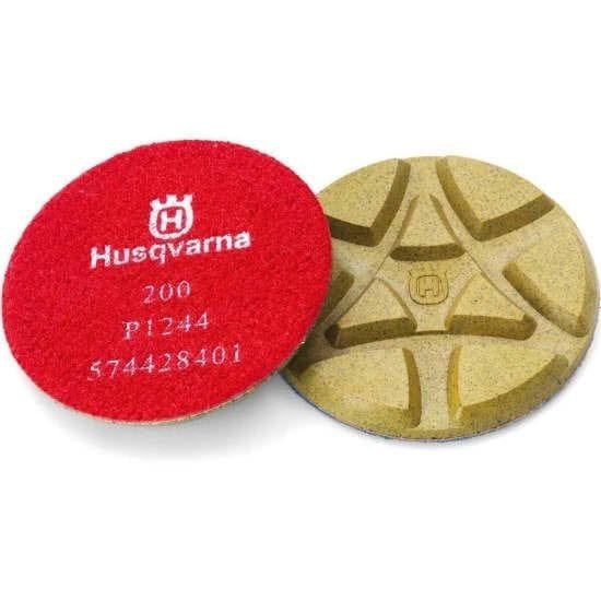 Husqvarna polishing pads shown side by side: one red pad labeled “200 P1244” and one tan pad with a geometric pattern; designed for dry concrete and terrazzo surface refinement