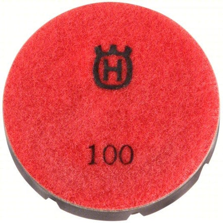 Red Husqvarna 3" polishing pad with felt-textured surface and black backing labeled “100” and crowned “H” logo; used for concrete finishing
