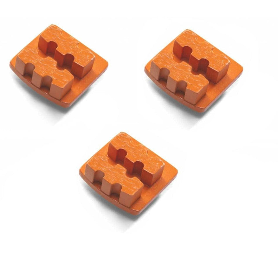 Three orange Husqvarna double-segment diamond grinding tools with interlocking ridged tops; designed for hard concrete and coating removal.